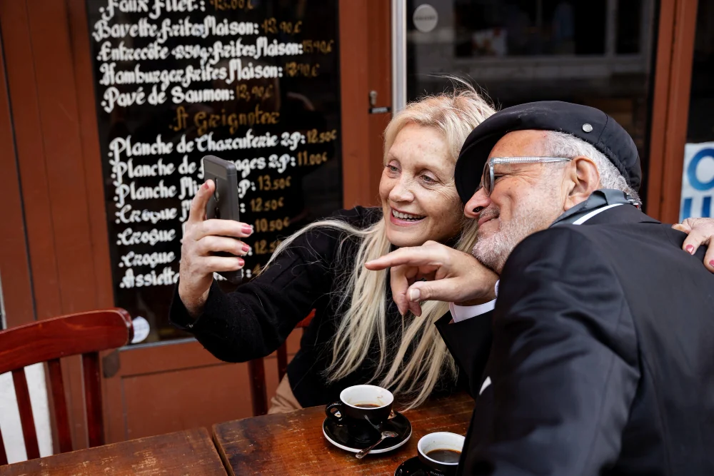 A mature couple taking a photo outside a café
