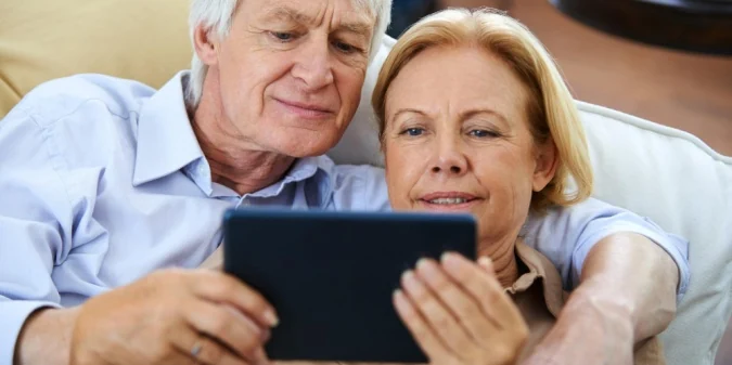 A couple reviewing a phone together on a terrace